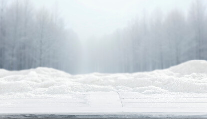 Winter landscape with fresh white snow and copy space for product placement or text. Blurred  snow-covered trees and cloudy winter sky background.