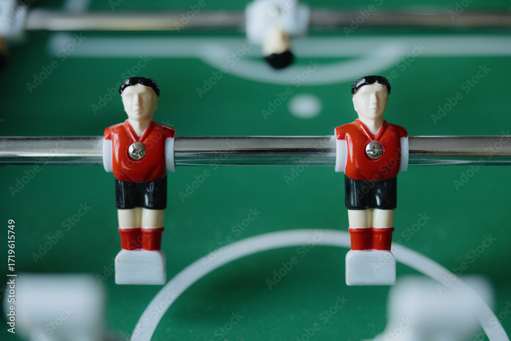 Fototapeta premium Dynamic soccer action unfolds on a green tabletop during a lively game