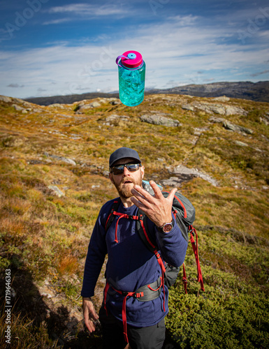 Man throwing a water bottle in the air 