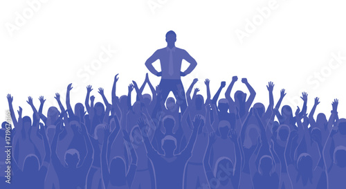 A single person standing above a cheering crowd of many people.