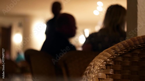 People relaxing in abstract night restaurant bar cafe with lens bokeh.