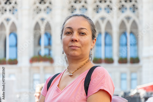 Portrait of a middle-aged woman in a city square on a sunny day.