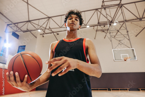 Teen basketball player practicing indoors