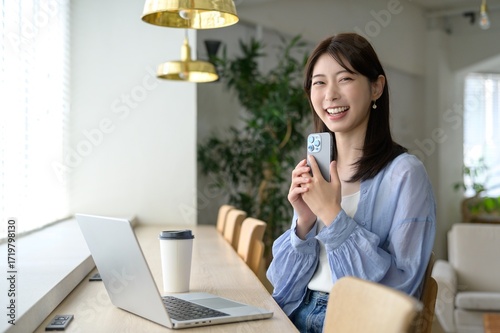 カフェの窓際でカメラ目線の日本人女性