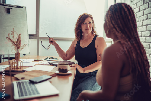 Fotografija Focused Black businesswoman communicates during creative exchange, portraying leadership, tech fluency, and purpose-driven work culture in modern digital teams