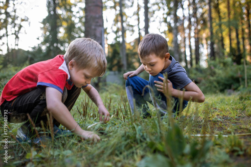 little children playing in garden squatting in the grass