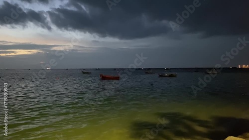 Tranquil Seascape at Dusk Featuring Boats and Dramatic Cloudy Sky Over Water