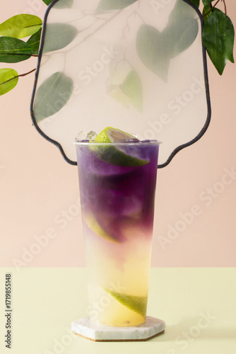 Refreshing lime mojito with white to purple gradient and lime slice
