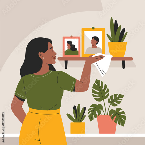 Young woman dusting a shelf with plants and pictures in a bright environment