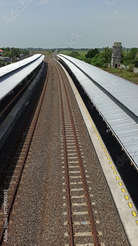 A quiet train station with minimal passengers, empty platforms, and soft lighting, capturing calm urban transport and serene early morning or late evening atmosphere.