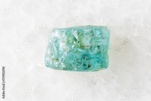 rough starlite blue zircon mineral on white marble