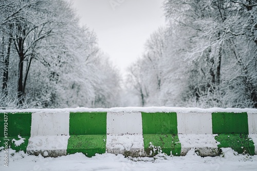 Snowy Winter Road Blockade with Green and White Concrete Barriers in Frosty Forest Scene