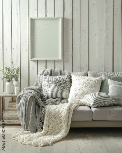 A comfortable living room scene featuring a cozy sofa, soft blankets, and patterned pillows arranged invitingly, with a neutral color palette and a light and airy atmosphere.