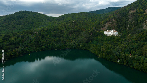 Aerial view of Lake Monticchio Grande, located in the crater of the ancient extinct volcano of Vulture Mount. It is located in the province of Potenza, Basilicata, Italy, and is surrounded by trees.