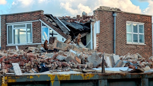 Photos Brick building demolition with collapsed roof and debris, useful for constructio