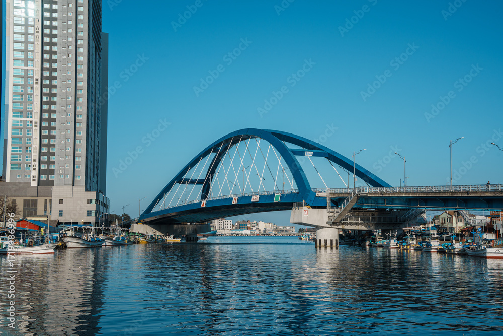 Obraz premium Sokcho harbor with fishing boats and modern skyscrapers, South Korea