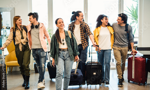 Young group of tourists with suitcases arriving at youth hostel guest house - Happy friends enjoying summer vacation together - Millenial people doing check-in at hotel lobby - Summertime holidays