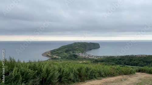 A large number of cars on the shore of a rocky island in Vladivostok.