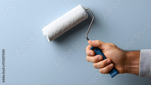  A clean and professional painter holding a paint roller with a blank wall