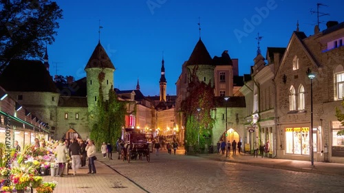 People walking in tallinn old town at night with illuminated buildings