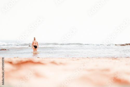 young woman walking on the beach in Lagos Portugal