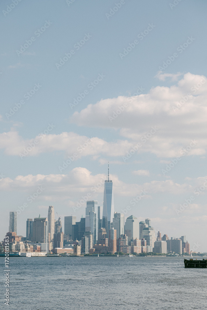 Obraz premium Skyline view of a bustling city with a prominent tall building in the center against a clear blue sky