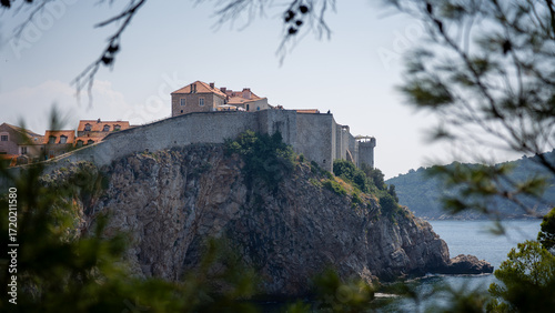 Obraz na płótnie View Through the Foliage: The Dubrovnik Ramparts on a Sunny Day