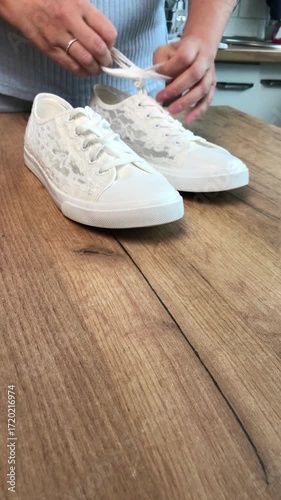 A woman reviewing white sneakers. Vertical video..
