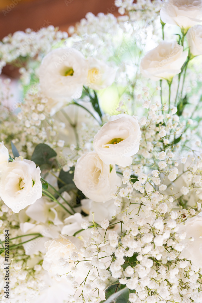 Obraz premium White floral bouquet with roses and daisies arranged in elegant vase for wedding table decoration, natural fresh flowers as romantic festive centerpiece for ceremony, celebration and reception event