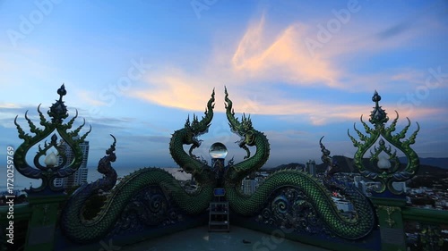 Video background of Chonburi city viewpoint. At the Samnaksong Khao Phra Khru viewpoint in the Sri Racha Thailand,a beautiful Naga statue and a white Buddha statue stand tall among the mountains.