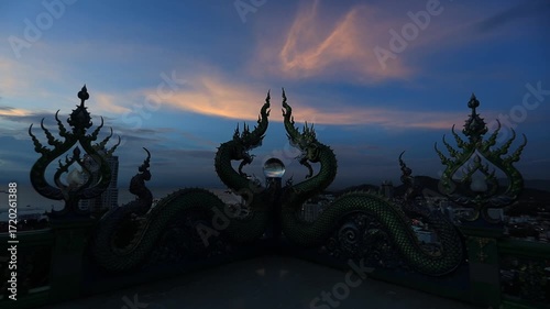 Video background of Chonburi city viewpoint. At the Samnaksong Khao Phra Khru viewpoint in the Sri Racha Thailand,a beautiful Naga statue and a white Buddha statue stand tall among the mountains.