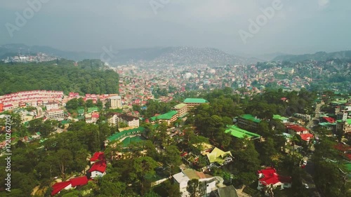 An aerial view of baguio city in the philippines shows buildings and trees