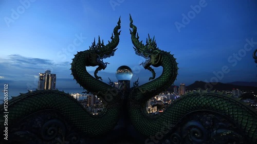 Video background of Chonburi city viewpoint. At the Samnaksong Khao Phra Khru viewpoint in the Sri Racha Thailand,a beautiful Naga statue and a white Buddha statue stand tall among the mountains.