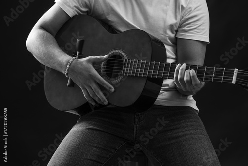 Black and white close-up of man playing acoustic guitar