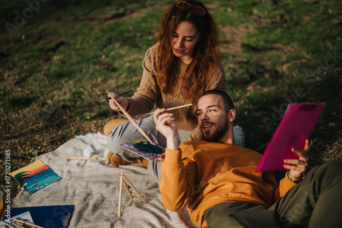 Fotografie A couple spends quality time together painting outdoors, enjoying art and creativity in nature