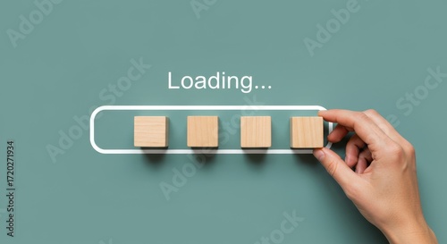 Hand loading progress bar with wooden blocks on a green background