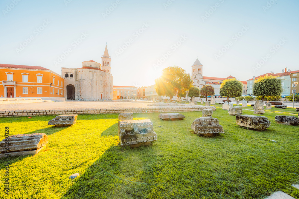 Fototapeta premium Zadar, Croatia. Old town street of Zadar with the Church of St. Donatus and the bell tower of the Cathedral of St. Anastasia at sunset.