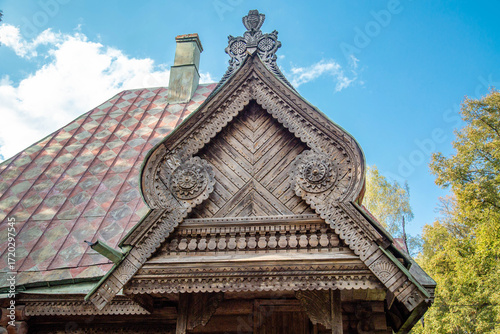 The facade of a wooden house with beautiful carved architraves on a clear sunny day. Sights of Russia, World tourism.