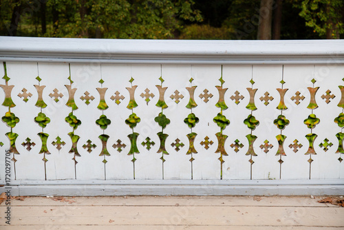 A white wooden fence with a beautiful carved pattern on a clear sunny day. Sights of Russia, World tourism.