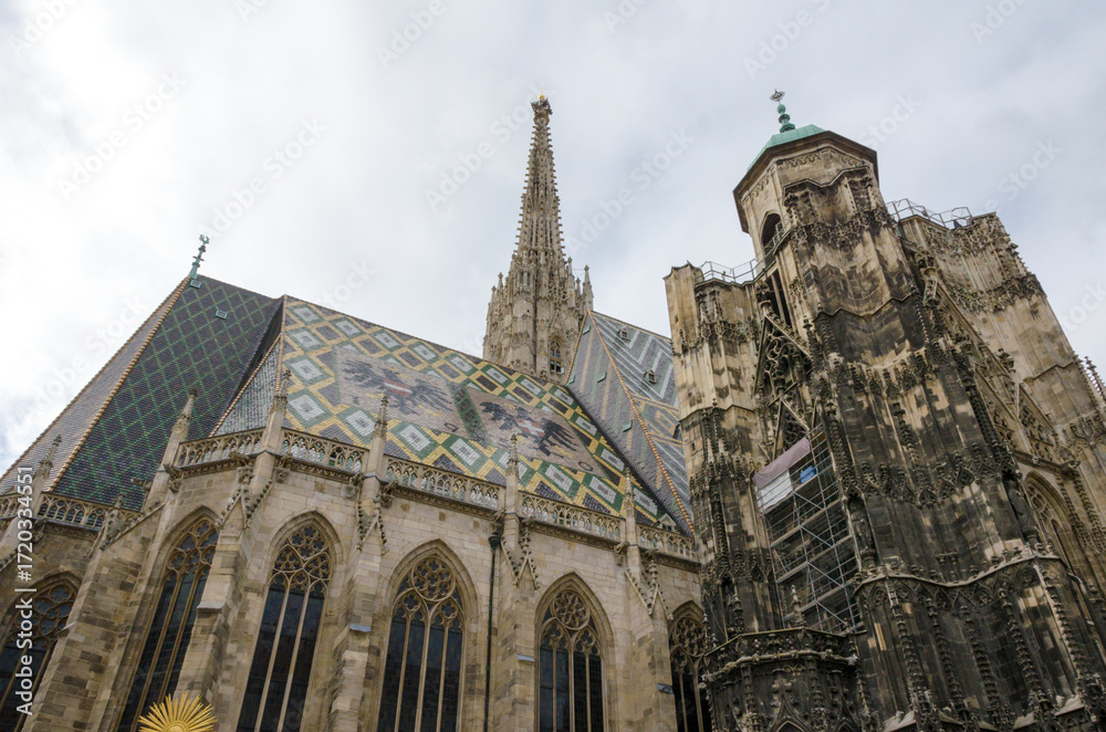 Fototapeta premium St. Stephen’s Cathedral in Vienna, Austria, with gothic spire and patterned roof.
