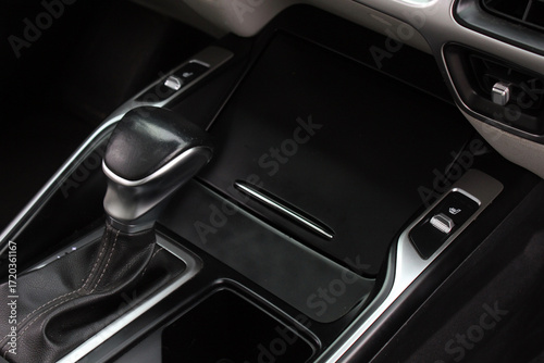 Black car center console with leather gear shifter, silver trim accents, and seat heating control buttons, combining modern design with practical functionality.