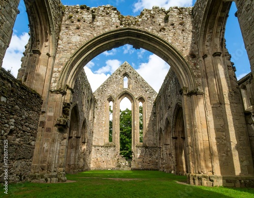 Ruined church interior with arches and grass
