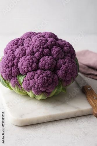 Photorealistic shot of rare purple cauliflower on marble cutting board with dewdrops and linen napkin, ultra-detailed food photography