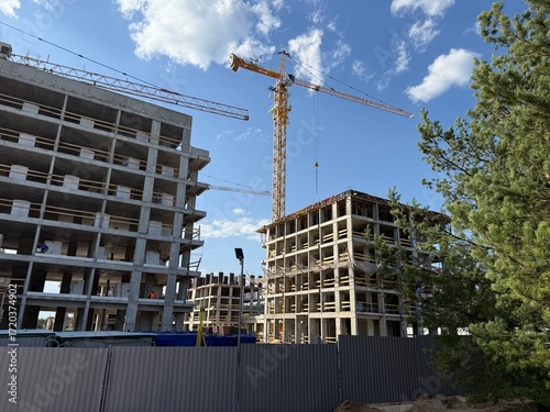 Construction site with cranes and modern buildings under development, real estate and architecture industry background
