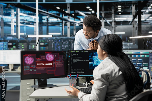 Φωτογραφία IT staff members in high tech facility trying to protect servers from hacker attack stealing sensitive information
