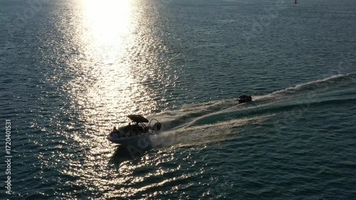 Aerial of a Motor Boat Towing a Group on a Tube