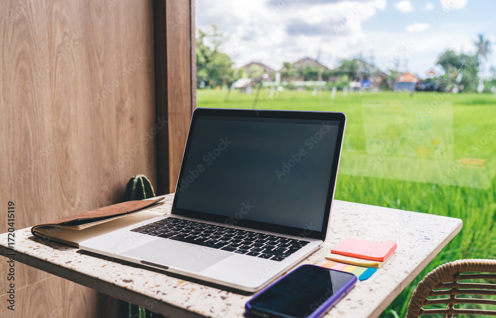 Fototapeta premium Young woman in orange activewear checks smartwatch on beach, symbolizing integration of wearable tech in personal fitness and digital health awareness.