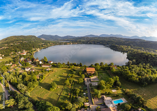 Aerial sunset view of Avigliana lake, Italy, Piedmont, Turin, Italy A beautiful town with and red-roofed houses, surrounded by the green hills of Susa and trees.italian lakes