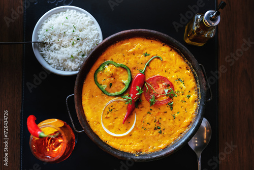 Shrimp, a typical food from the Brazilian Northwest made with shrimp and dendé oil, with tomato and pepper, accompanied by rice in a clay pot.