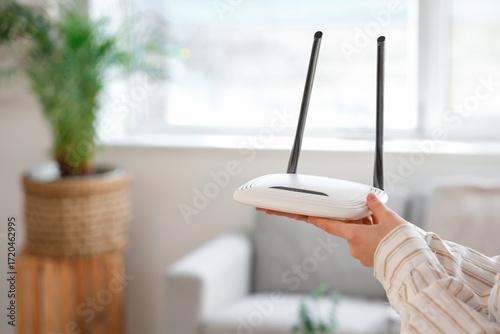 Obraz na płótnie Woman with modern wi-fi router at home, closeup